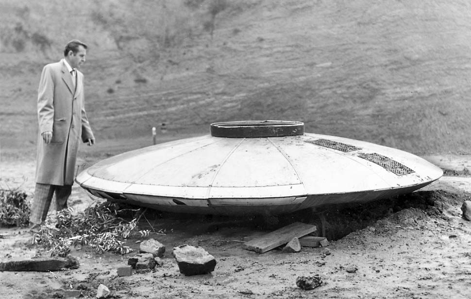 24 Jan. 1957 : Dewey Linze, auteur spécialiste de l'aviation du Los Angeles Times, examine une soucoupe    volante trouvée dans les collines d'Hollywood.