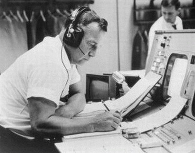 Chop, officier ajoint MSC des relations publiques, à sa console de la Salle des Opérations du Contrôle de Mission dans le Centre de Vol Habité de Houston, lors d'une simulation Gemini-Titan 4, le 30 mai 1965