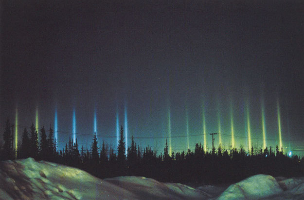 Des piliers de lumière à Fairbanks (Alaska), reflétant les lumières d'une patinoire 
