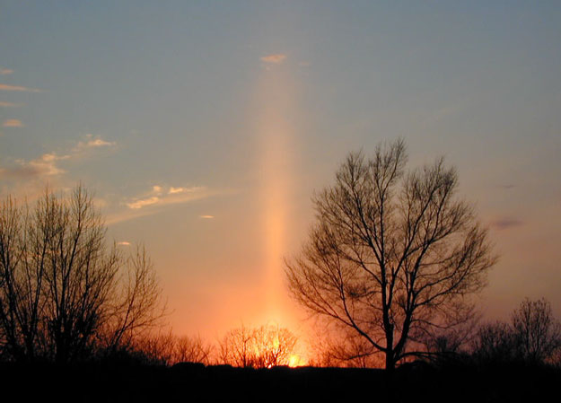 Un pilier formé par la lumière du Soleil couchant, se reflétant sur des cristaux de glace plats tombant lentement    vers le sol 1Stan Richard
