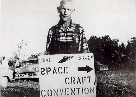 Nelson tenant le panneau d'une convention sur les appareils spatiaux les samedi 28 et      le lendemain s1[Look Magazine, Edition spéciale sur les Soucoupes Volantes, 1967]