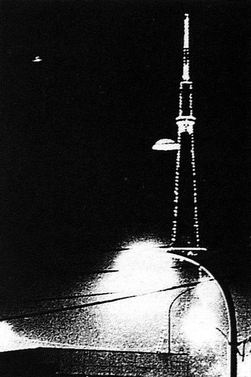 L'ovni photographié à Tokyo le 19. Une explication proposée est qu'il s'agisse du reflet du        lampadaire (en bas à droite), un des fils électriques faisant la séparation avec le "dôme" de la soucoupe        1Maillot, Eric: Mystère de l'Est